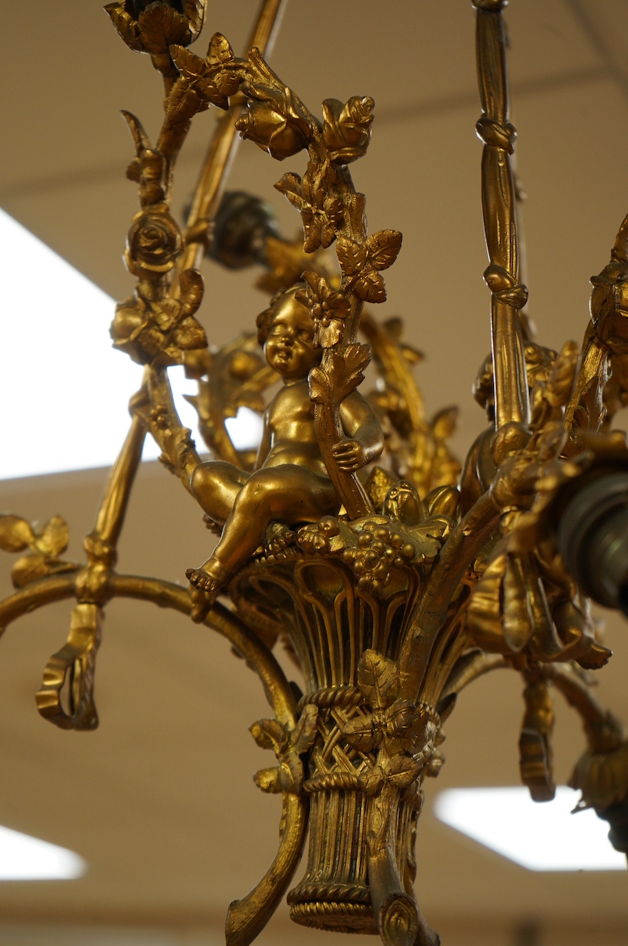 A gilt metal chandelier in the form of a cherub in a basket, 65cm high. Condition - fair, untested